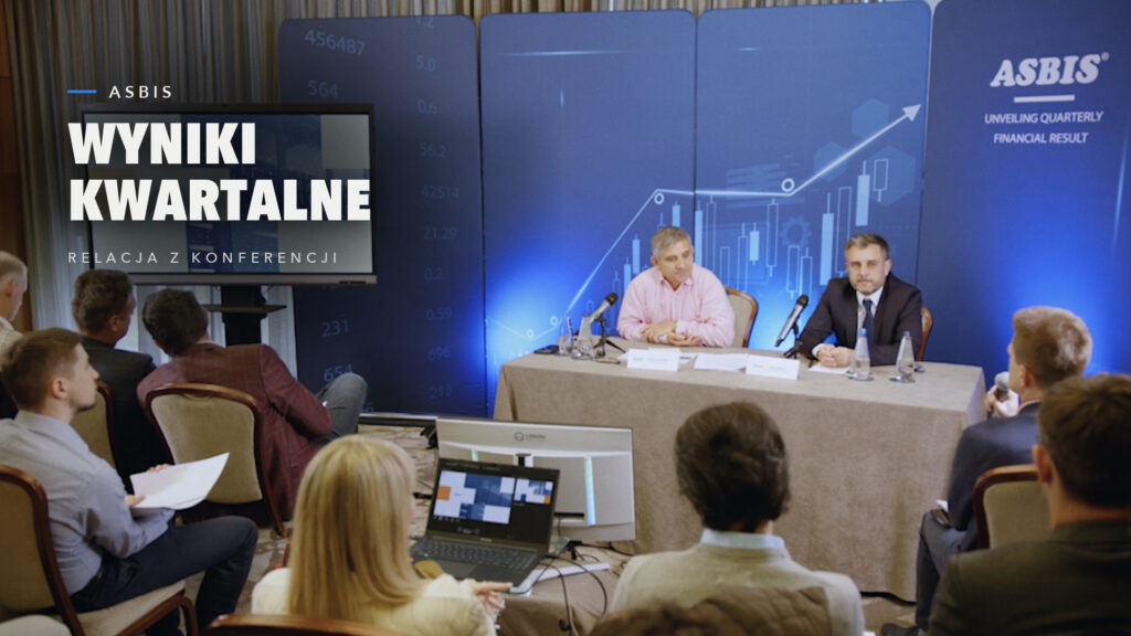 Konferencja prasowa ASBIS o kwartalnych wynikach finansowych, prelegenci przy stole i dziennikarze na sali, kadr z relacji 302 Studio